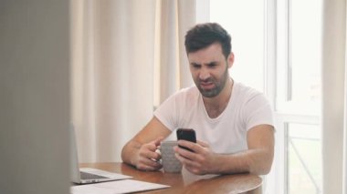 İş adamının sıcak kahve içerken akıllı telefon kullandığı 4K video..