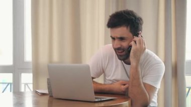 İş adamının evdeki ofis masasında otururken yaptığı bir telefon görüşmesinin 4K videosu..