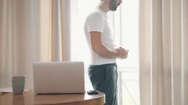 Evde dizüstü bilgisayar kullanan yakışıklı bir gencin 4K videosu..
