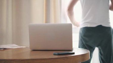 Evde dizüstü bilgisayar kullanan yakışıklı bir gencin 4K videosu..