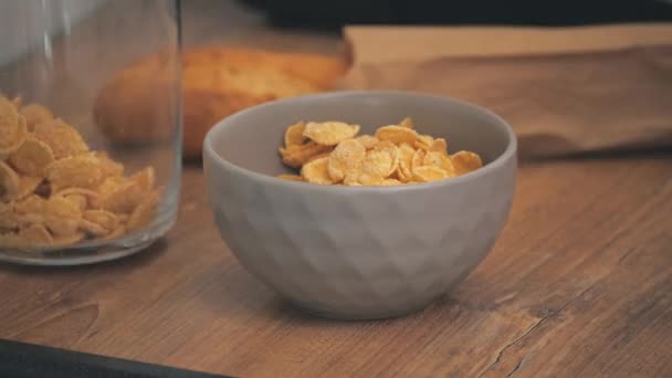 4k video av man hand sätta en skål med cornflakes på bordet. — Stockvideo