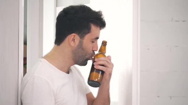 4k rallentatore video di uomo stanco baciare una bottiglia di birra e chiudere la porta. — Video Stock