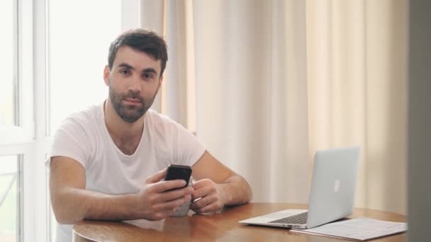 4k videó az üzletemberről, aki okostelefont használ, miközben forró kávét iszik. — Stock videók
