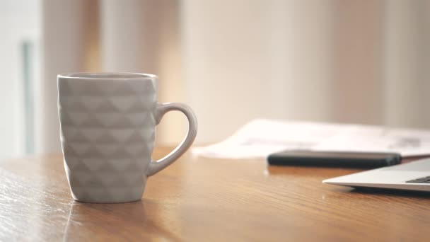 4k videó az üzletemberről, aki okostelefont használ, miközben forró kávét iszik. — Stock videók