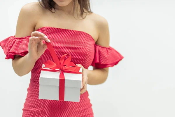 Julfirande koncept. Nyfiken ung kvinna håller en present låda ivrig att fing ut wht är inne. — Stockfoto