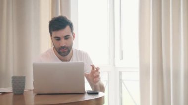 İş adamının dizüstü bilgisayarda çalışıp evde çay içişini gösteren 4k yavaş çekim videosu.