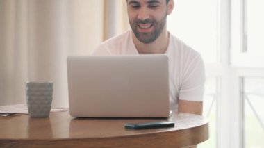 İş adamının dizüstü bilgisayarda çalışıp evde çay içişini gösteren 4k yavaş çekim videosu.