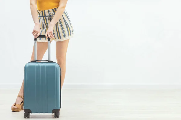 Blick auf Frauenbeine mit blauen Koffern auf weißem Hintergrund. — Stockfoto