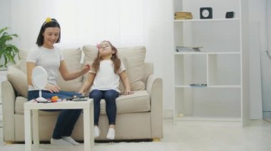 Anne ve kızının oturma odasında makyaj yaptığı 4K video..