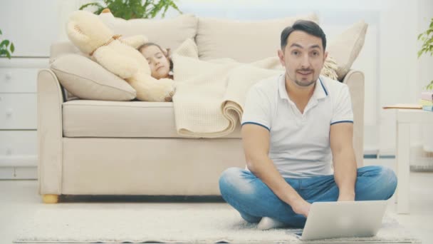 4k video donde papá escribe a la madre cuya hija duerme en su sofá. — Vídeos de Stock