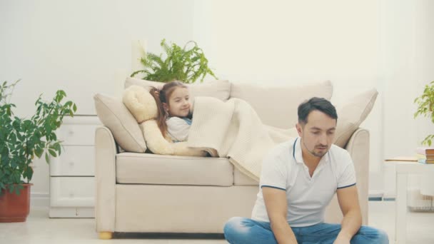 父親はオンライン中に彼の娘はソファに横たわって、その後4kビデオで彼を抱きしめる. — ストック動画