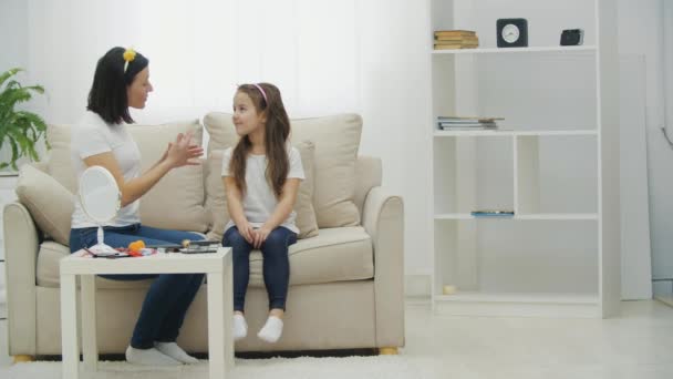 Vidéo ralenti 4k de deux femmes assises sur le canapé avec des cosmétiques. — Video