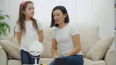 4K video anne evde küçük kızı için makyaj yapıyor..