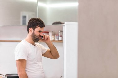 Beyaz arka planda izole bir şekilde telefonla konuşan genç bir adamın portresi..