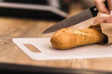 Fırında pişmiş ekmeğin fotoğrafı kesim tahtasının üzerinde duruyor..