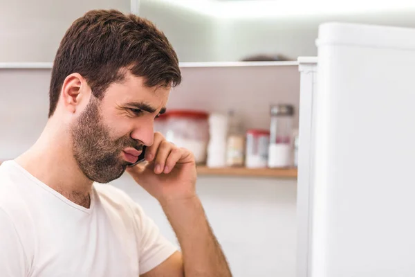 Cool man med skägg pratar i telefon och tittar ner med kopieringsutrymme. — Stockfoto