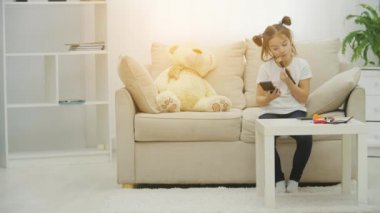 4K videoda küçük bir kız makyaj yapmaya çalışıyor..