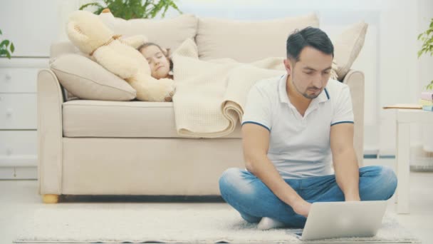 Vader is online terwijl zijn dochter slaapt op een achtergrond in 4k slowmotion video. — Stockvideo