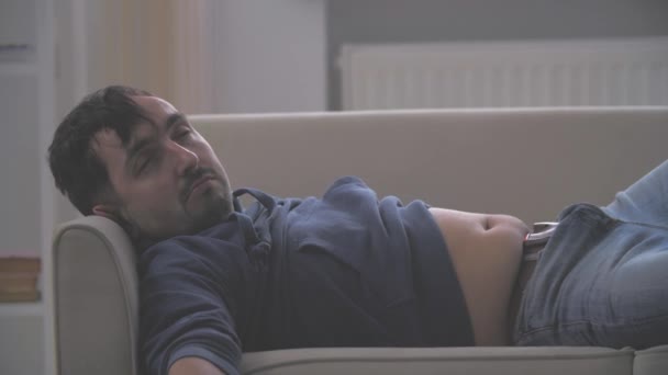 4k slow motion video waar druck man slaapt op een bed. Ontwaken uit een kater. Close-up. — Stockvideo