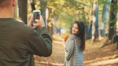 Güz Ormanı Parkı 'nda sevgili bir çift fotoğraf çekiyor. Uzayı kopyala Arka plan bulanık. 4K