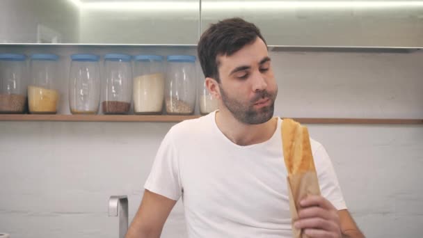 4k video vousatý hladový muž kousání čerstvý bochník chleba. — Stock video