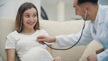 Hamile bir kadını steteskopla muayene eden bir doktorun 4k yavaşlatılmış videosu..