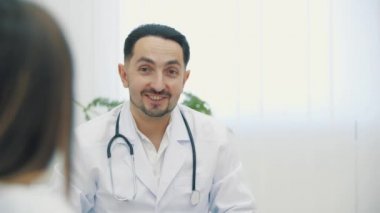 Kameraya poz veren ve gülümseyen neşeli olgun doktorun 4k yavaş videosu..