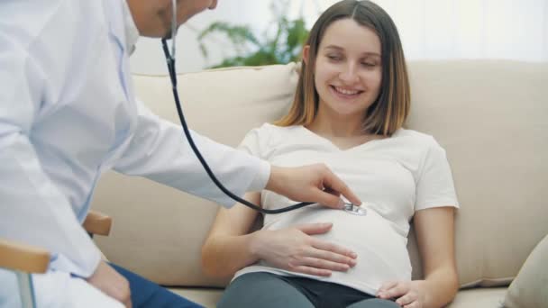 4k vídeo de um médico examinando a mulher grávida com um estetoscópio. — Vídeo de Stock