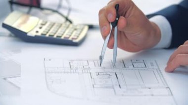 Mühendis elinin pusula ile bir inşaat projesi çizdiği yavaş çekim videosunu kapat.
