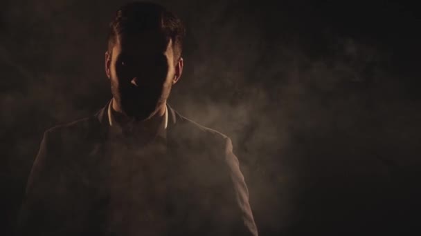 4k slow motion vídeo de um homem maduro no fundo preto com fumaça. — Vídeo de Stock