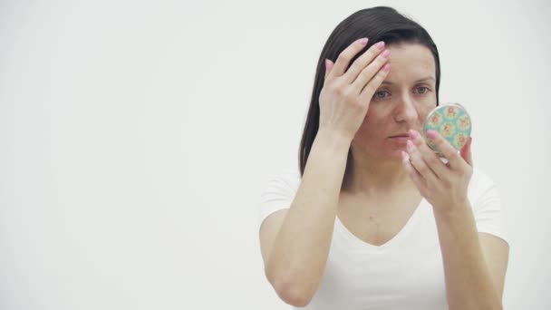 4k видео женщины, у которой проблемы с кожей, смотрит в зеркало. — стоковое видео