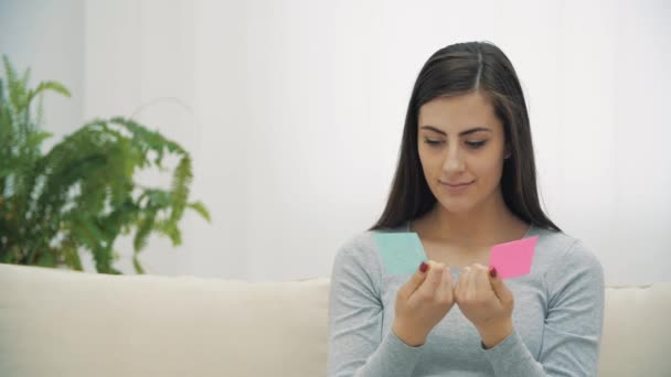 4k video of pregnant woman holding pink and blue papers with written words boy and girl. — Stock video