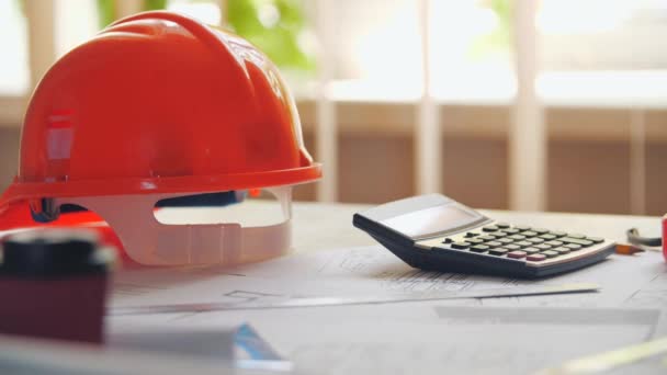 4k close up video of orange helmet and calculator on the table. — Video Stock