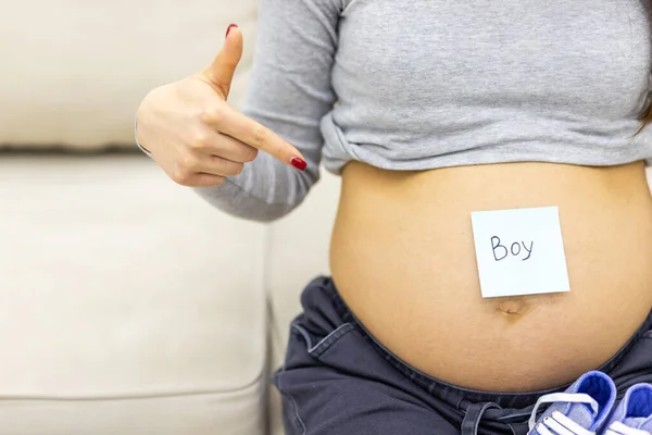 Foto der schwangeren Frau Bauch mit geschriebenem Wort Junge auf dem Papier. — Stockfoto