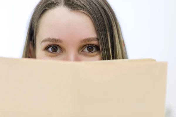 Žena skrývající svou tvář knihou. — Stock fotografie
