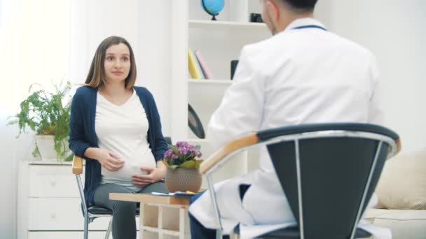 4k cámara lenta de vídeo de la mujer embarazada hablando con un médico. — Vídeo de stock