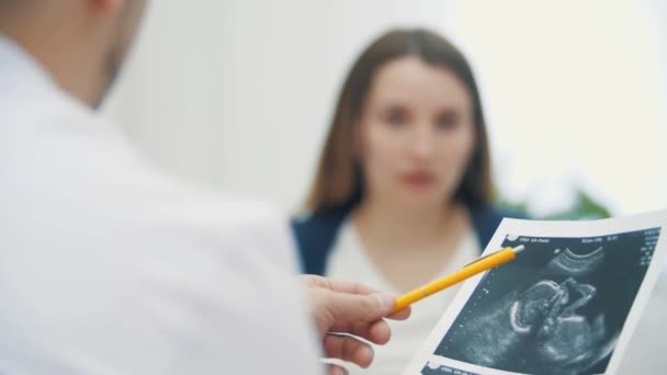 Hamile kadın ve doktorun ultrason sonuçlarını gösteren 4k 'lik bulanık hareket videosu. — Stok video
