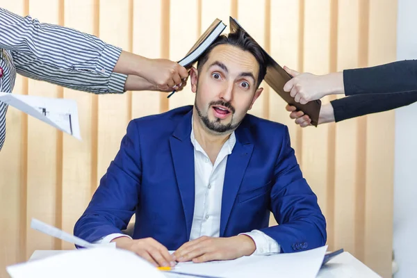 Photo d'un homme d'affaires en costume bleu ayant beaucoup de travail assis dans le bureau. — Photo