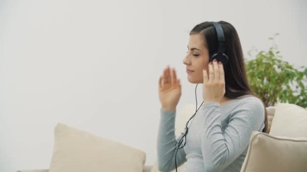 임산부가 헤드폰으로 음악을 듣는 4k 비디오. — 비디오