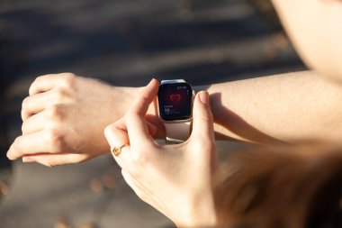 Poznan, Polonya - 24 Eylül 2025: Kişisel sağlık ve kondisyon yönetimi için kalp atış hızını gösteren Apple Watch ekranını izleyen bir kişinin yakın çekimi