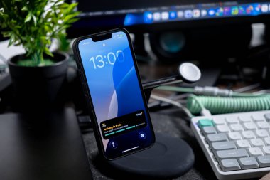 Poznan, Polonya - 1 Ekim 2025: Dijital çalışma alanında iPhone ekranını şarj etme amaçlı Glovo uygulaması, kentsel gıda ve market dağıtımında verimli güncellemeleri gösteriyor