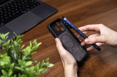 Poznan, Polonya - 16 Ekim 2025: Eller yeni iPhone 17 Pro 'yu akıllı telefon güvenliği ve dayanıklı teknoloji donanımına vurgu yaparak Yerli Birliği koruma çantasına yerleştiriyor