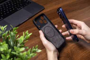 Poznan, Polonya - 16 Ekim 2025: iPhone 17 Pro için Doğal Birlik davası, modern mobil kullanım için temel cihaz korumasını vurgulayarak mavi akıllı telefonun yanında sunuldu