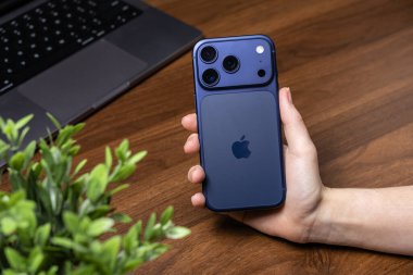 Poznan, Polonya - 16 Ekim 2025: iPhone 17 Pro, elde tutulan mavi akıllı telefon, fotoğraf, iletişim ve dijital kullanım için gelişmiş özellikleri vurguluyor