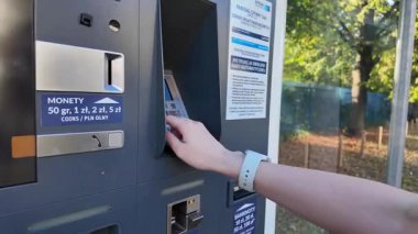 Poznan, Polonya - 8 Ağustos 2025: Bir APCOA otopark makinesinin elle etkileşime girmesi, kentsel alanlarda kamu park için verimli ödeme süreçlerini göstermesi
