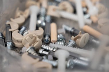 Metal vidalar, plastik cam kilitleri ve ahşap bölmeler gibi çeşitli küçük mobilya tesisatlarının detaylı bir yakın plan koleksiyonu, ev montajı ve düz paket mobilya inşaatı için hayati önem taşıyor.