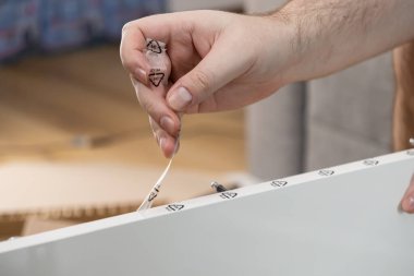 Beyaz mobilya tahtasından geri dönüşüm sembolü 04 PE-LD ile el yapımı temiz plastik film, ekolojik bilinçli ambalaj ve kolay DIY mobilya montaj süreci teşvik