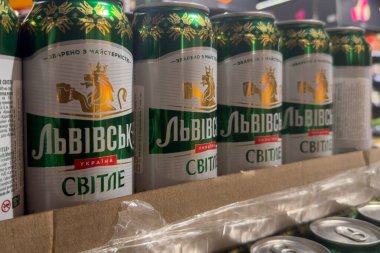 Poznan, Polonya - 22 Kasım 2025: Lvivske Svitlye bira kutuları yeşil ve beyaz ambalajlı, altın aslan amblemi, tüketiciler için bir mağaza rafında düzgünce düzenlenmiş