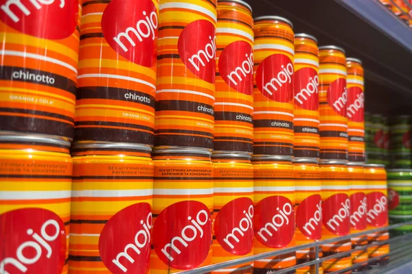 Poznan, Polonya - 22 Kasım 2025: Perakende satış mağazasında kendine özgü parlak turuncu ve kırmızı markalardan oluşan Mojo Chinotto soda kutularının yakın görüntüsü