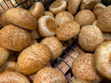 Çok sayıda altın kahverengi susamlı çöreğin yakın plan görüntüsü taze pişmiş dokularını gözler önüne seriyor, sağlıklı yemek için mükemmel, market vitrinleri, veya günlük restoran malzemeleri.